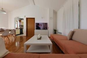 un soggiorno con un divano e un tavolo di Holiday house Marea with jacuzzi a Crikvenica