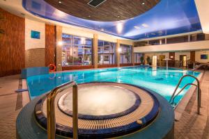 a large swimming pool in a hotel room at Hotel Prezydent Krynica Zdrój in Krynica Zdrój