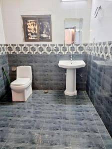 een badkamer met een toilet en een wastafel bij Hotel Visit Inn Executive in Lahore