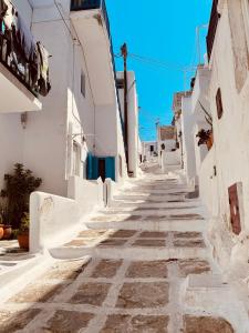 an alley with white buildings and a blue sky at Mykonian Starling - Town n' Sunset View Apartment in Mikonos
