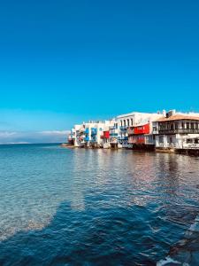 a large body of water with houses and buildings at Mykonian Starling - Town n' Sunset View Apartment in Mýkonos City