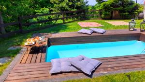 a pool with a wooden deck and a table and chairs at Golden Mountain in Anilio Pelion