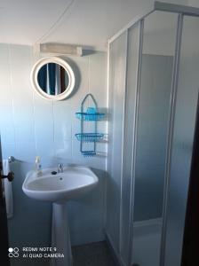 uma casa de banho com um lavatório e um chuveiro em Alojamento Dona Inês de Castro em Atouguia da Baleia