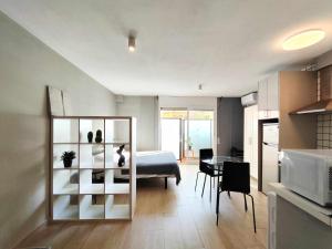 um quarto com uma cama e uma cozinha com uma mesa em Mazi Apartments Suite em Mataró