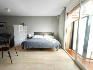 um quarto com uma cama, uma mesa e uma cadeira em Mazi Apartments Suite em Mataró