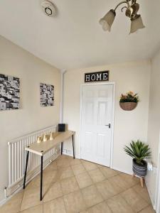 a room with a table and a door with a home sign at Warm Contractor-Friendly Home in Luton