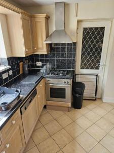 a kitchen with wooden cabinets and a stove top oven at Warm Contractor-Friendly Home in Luton