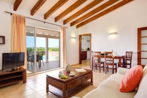 a living room with a couch and a tv at Villas Menorca Sur in Son Bou