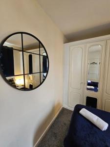 a room with a mirror and a blue couch at Warm Contractor-Friendly Home in Luton