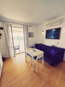 uma sala de estar com um sofá azul e uma mesa em Apartments Sv.Jakov em Dubrovnik