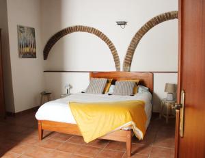 een slaapkamer met een bed met een houten hoofdeinde bij Casa Refúgio in Évora