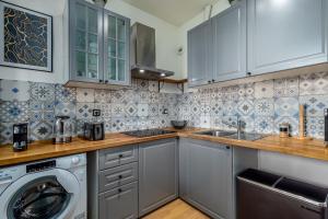 cocina con armarios blancos, lavadora y secadora en Berge - Appartement proche Disneyland Paris, en Meaux
