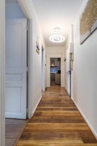 a hallway with a white door and wooden floors at Berge - Appartement proche Disneyland Paris in Meaux
