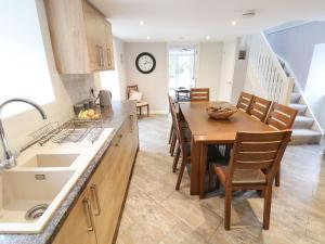 a kitchen and dining room with a table and chairs at Nant Coed Barn in Abergele
