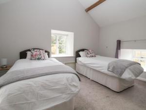 A bed or beds in a room at Nant Coed Barn