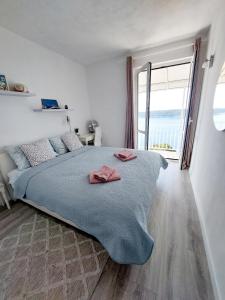 um quarto com uma cama grande e uma janela grande em Apartments Sv.Jakov em Dubrovnik