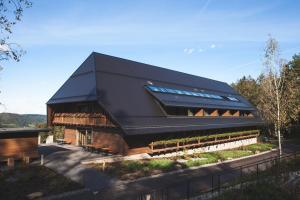 un grand bâtiment avec un toit noir dans l'établissement Hotel Munde, à Hofstetten