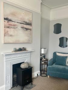 sala de estar con sofá azul y chimenea en Pebbles, en Lynton
