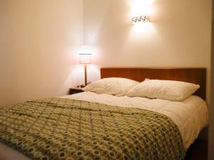 1 dormitorio con 1 cama con 2 almohadas y lámpara en Appartement Le Palais, 2 pièces, 3 personnes - FR-1-418-230, en Le Palais