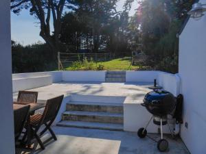 a patio with a grill and a table and chairs at Maison Sauzon, 5 pièces, 8 personnes - FR-1-418-201 in Sauzon