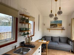 una cocina con fregadero y un sofá en una habitación en Tiny House 300 Meter vom Zentrum entfernt, en Eberswalde