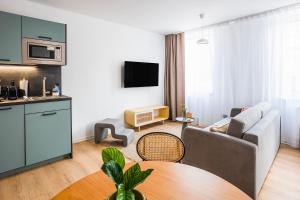 een woonkamer met een bank en een tafel bij limehome Villach Hauptplatz in Villach