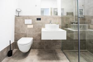 y baño con aseo, lavabo y ducha. en limehome Villach Hauptplatz en Villach