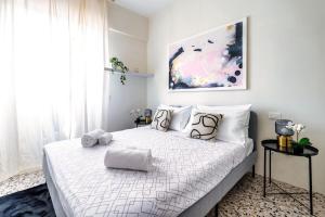 ein weißes Schlafzimmer mit einem großen weißen Bett mit Kissen in der Unterkunft Art House - You're home in Porta Venezia in Mailand