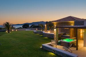 a villa with a pool and a tv on a lawn at Quinta Essentia Suites in Foiníki