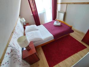 グリツァルフにあるTatrzańska Panoramaの赤い敷物が敷かれた小さな部屋の小さなベッド1台