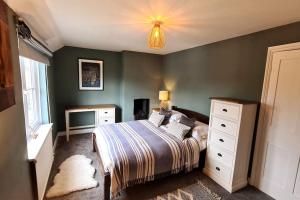 a bedroom with a bed and a dresser at Gorgeous Two Bedroom House in Ely in Ely