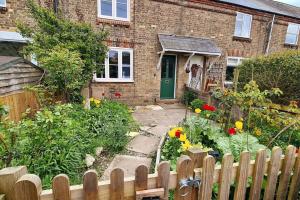 a garden in front of a house with a wooden fence at Gorgeous Two Bedroom House in Ely in Ely