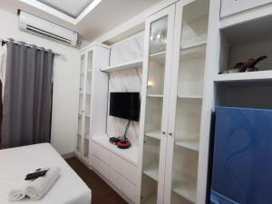 um quarto branco com uma televisão e um armário branco em ARSAKHA 003 Transpark Cibubur By Karlina em Kalimanggis