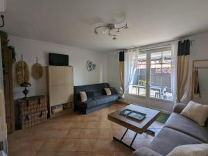 a living room with a couch and a table at L'Instant Mer - Bord de Mer - Studio avec grand jardin à La Capte in Hyères