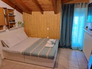a bedroom with a bed with towels on it at Attic in Nea Moudania