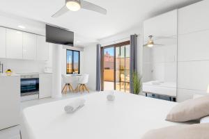 biała kuchnia i salon z dużym łóżkiem w obiekcie MEDANO4YOU White Dream Penthouse w mieście El Médano