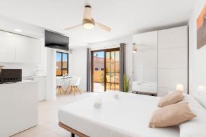 Biała sypialnia z dużym łóżkiem i kuchnią w obiekcie MEDANO4YOU White Dream Penthouse w mieście El Médano