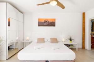 biała sypialnia z łóżkiem i wentylatorem sufitowym w obiekcie MEDANO4YOU White Dream Penthouse w mieście El Médano +36 zdjęć