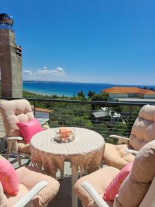 een tafel en stoelen op een balkon met uitzicht op de oceaan bij Attic in Nea Moudania