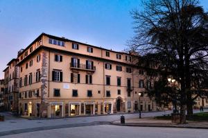 a large building on the side of a street at Grand Universe La Residenza in Lucca