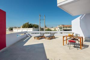 un patio con mesa y sillas en la azotea en Fata Morgana Apartment en Ialyssos