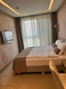 Un dormitorio con una cama grande y una ventana en City Park Inn - Art Gallery, en Plovdiv