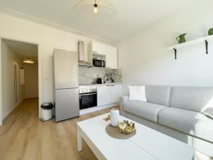 a white living room with a couch and a table at Studio bord de mer 3 in Menton