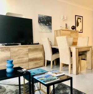 a living room with a table with chairs and a television at CHARMING APARTMENT NEAR THE BEACH in Villefranche-sur-Mer