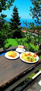 three plates of food sitting on a wooden table at Golden Mountain in Anilio Pelion