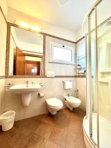 a bathroom with a sink and a toilet and a mirror at Residence Mareo in Riccione