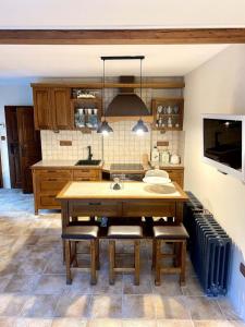 a kitchen with a wooden table and some chairs at Apartment Holín in Holín