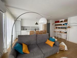a living room with a gray couch with colorful pillows at Alojamiento Armenia Patio in Alcalá de los Gazules