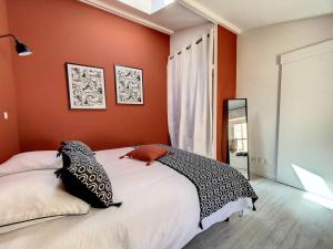 a bedroom with a large bed with orange walls at Bienvenue à la Tatoo Room in Bourgoin