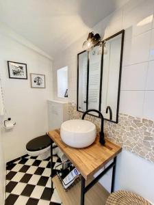 a bathroom with a sink and a mirror on a table at Bienvenue à la Tatoo Room in Bourgoin